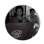 Foto de rosto em preto e branco de Maria Eduarda Rodrigues, com uma bandeira do Movimento dos Trabalhadores Sem Teto, para a Memória Popular da Pandemia. A foto acompanha relato sobre as atividades do MTST na pandemia, como a distribuição de máscaras e cestas.